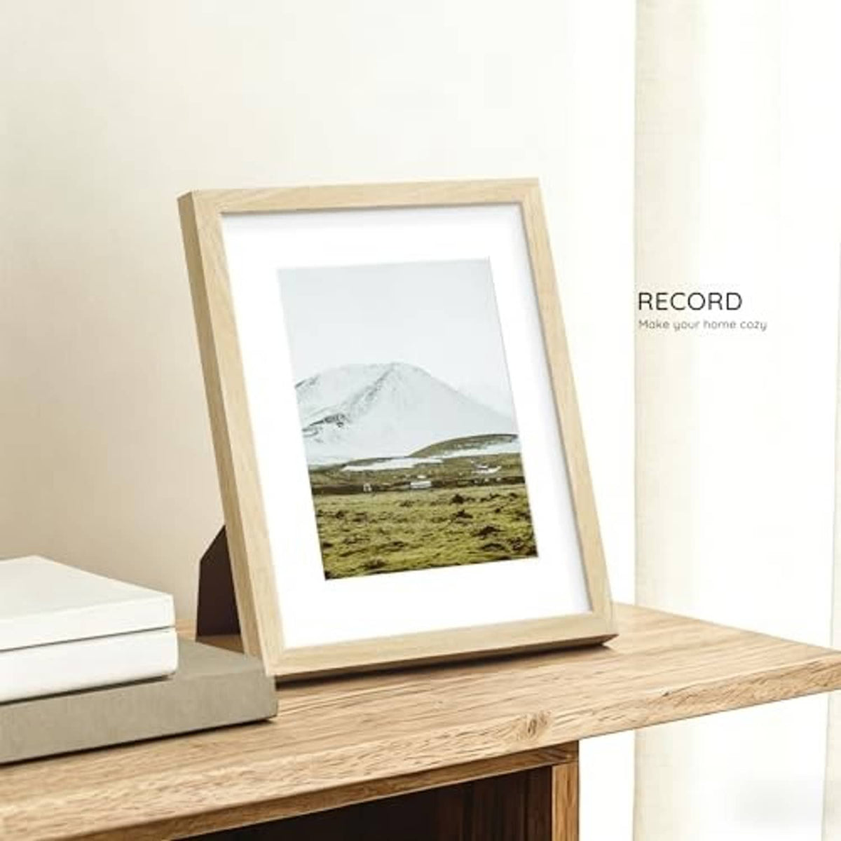 Natural oak 8.5x11 solid wood picture frame standing on a shelf with landscape print.