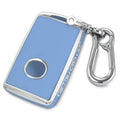 Blue key fob cover with silver trim, circular button cutout, and metal keychain hook