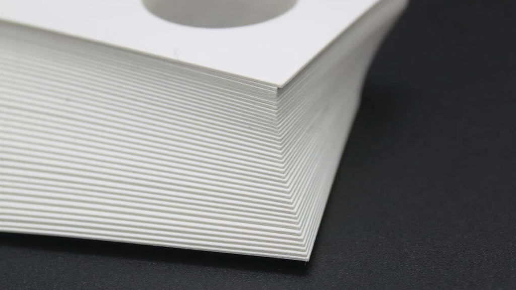 Stack of white coin flip cards with oval coin openings along the edge