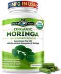 Organic moringa leaf powder capsules bottle with green capsules and moringa leaves
