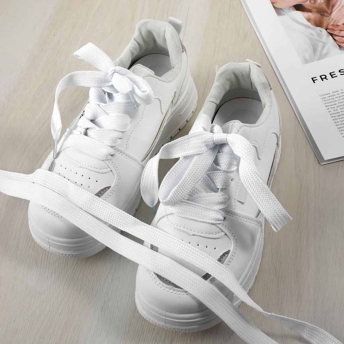 White sneakers with long woven shoe laces draped across