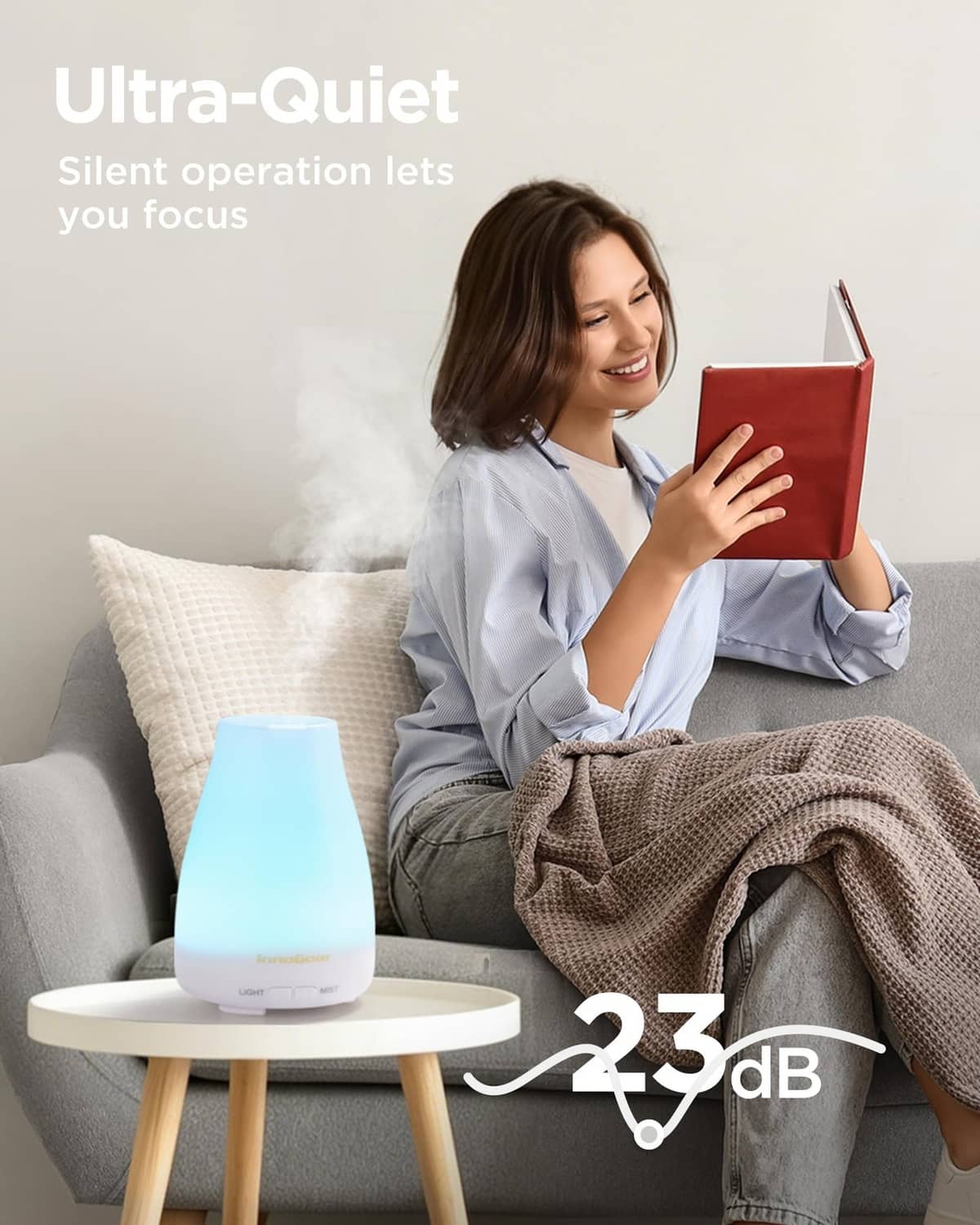 White essential oil diffuser with cool blue LED glow, on a side table