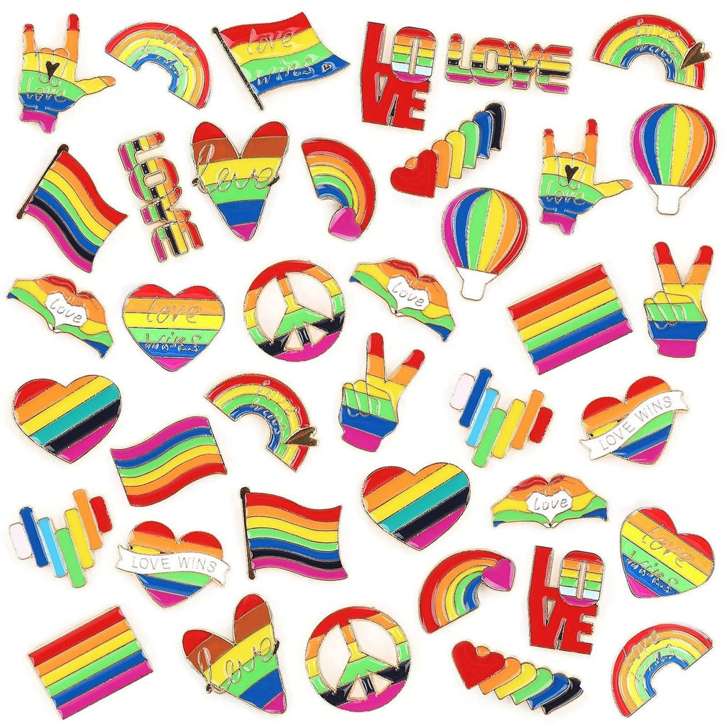 Assorted rainbow Pride enamel pins, including hearts, rainbows, and hand symbols.