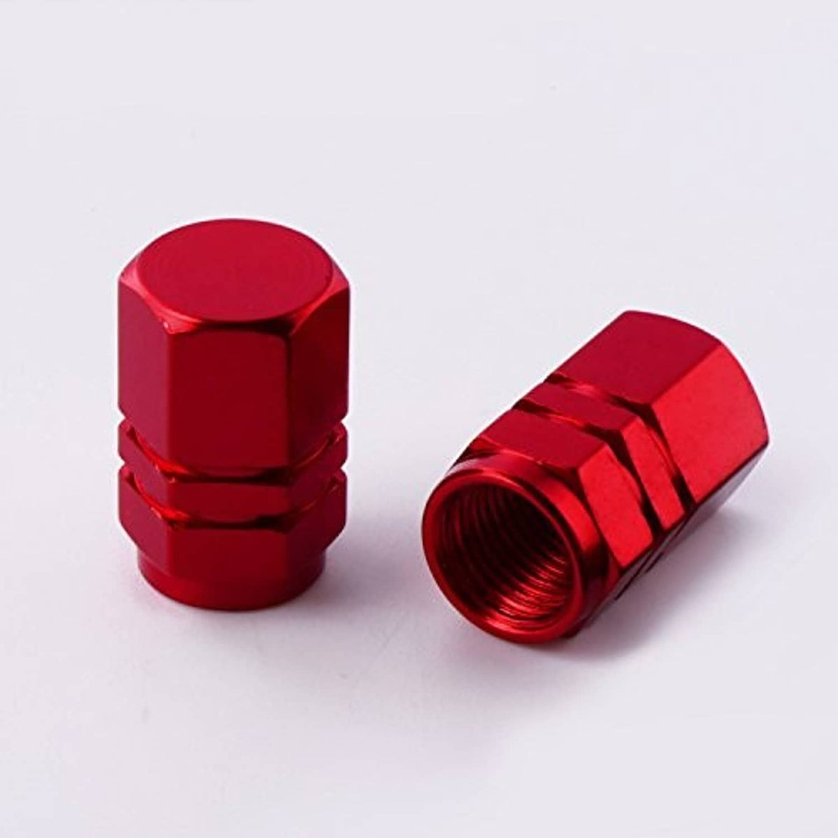 Red valve stem caps with hex top and threaded inner opening, ridged metal exterior