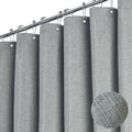 Grey linen-textured shower curtain panels with metal grommets on top and fabric texture circle