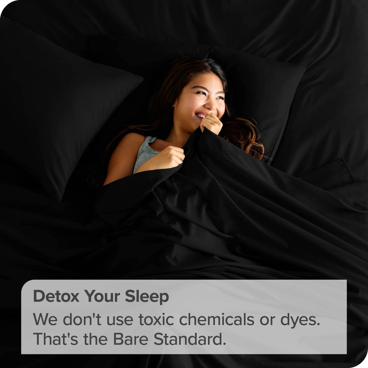 Black flat sheet covering a bed with smooth folds and folded corner