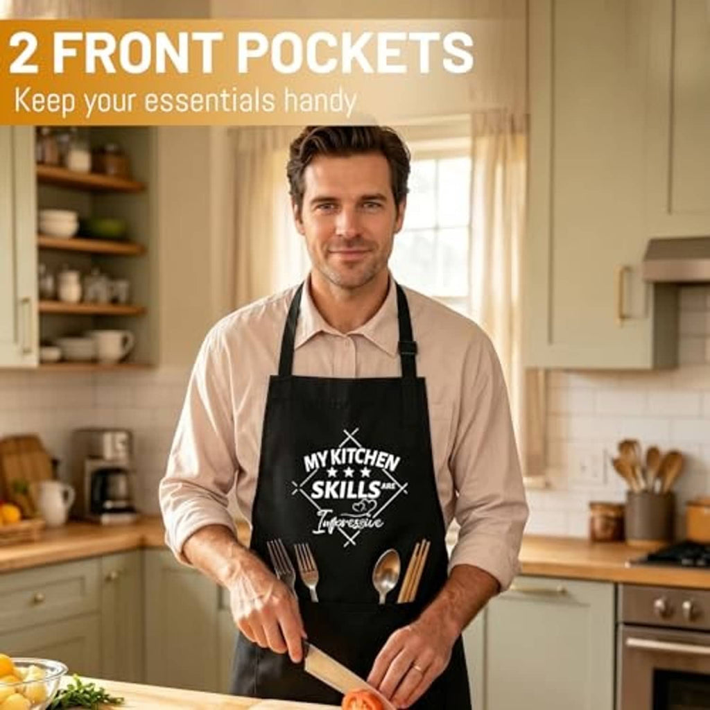 Black cooking apron with two front pockets and kitchen skills utensils graphic