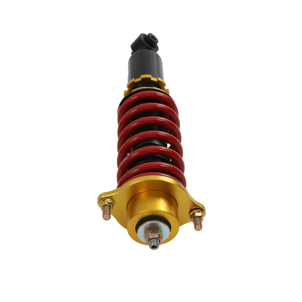 Close-up coilover top mount with gold perch, red spring coils, and black upper housing.