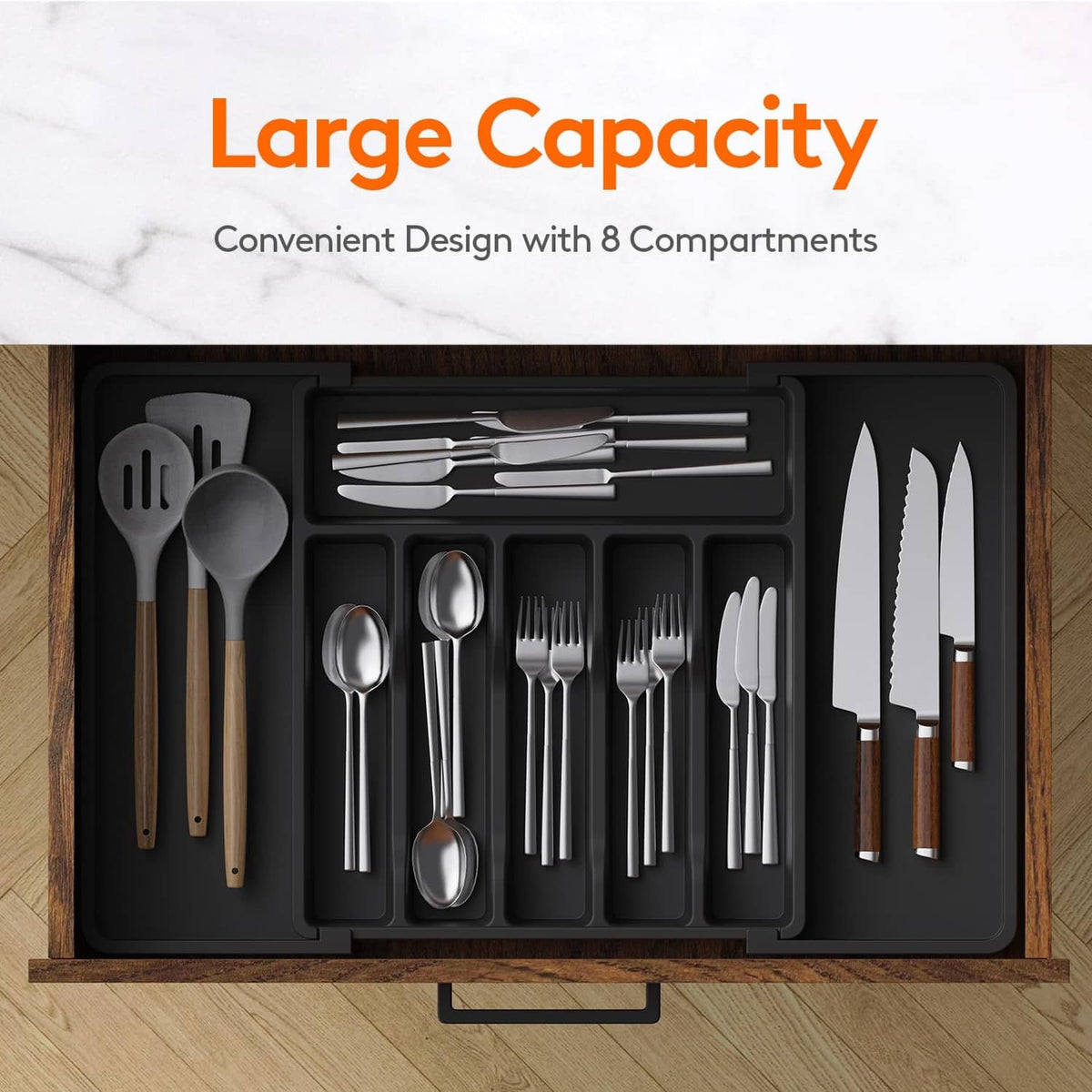 Dark utensil organizer tray with compartments holding assorted cutlery pieces