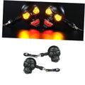 Pair of skull LED motorcycle turn signal lights with glowing red tail and yellow turn lamps