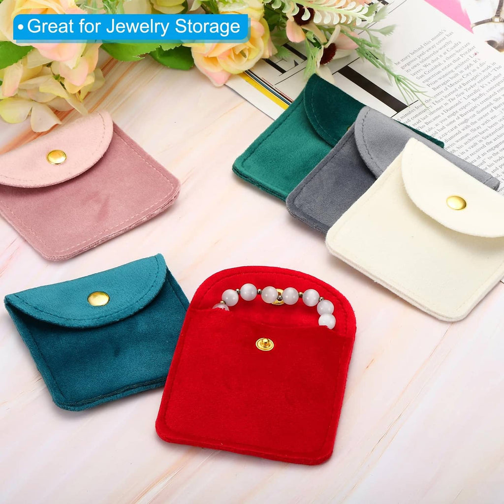 Assorted jewelry pouches in dark green, pink, blue, white, each with snap button