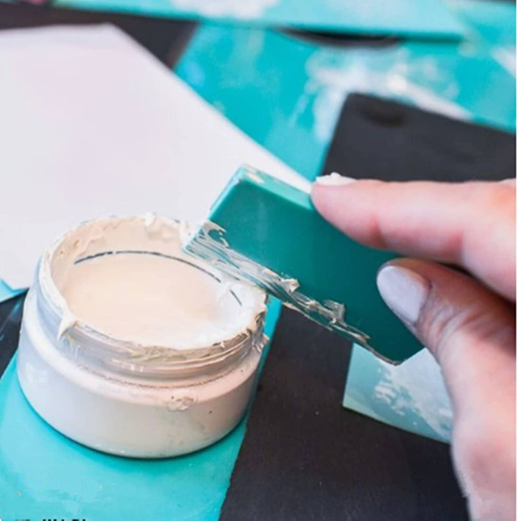 Cream chalk paste ink jar being spread across a screen printing frame