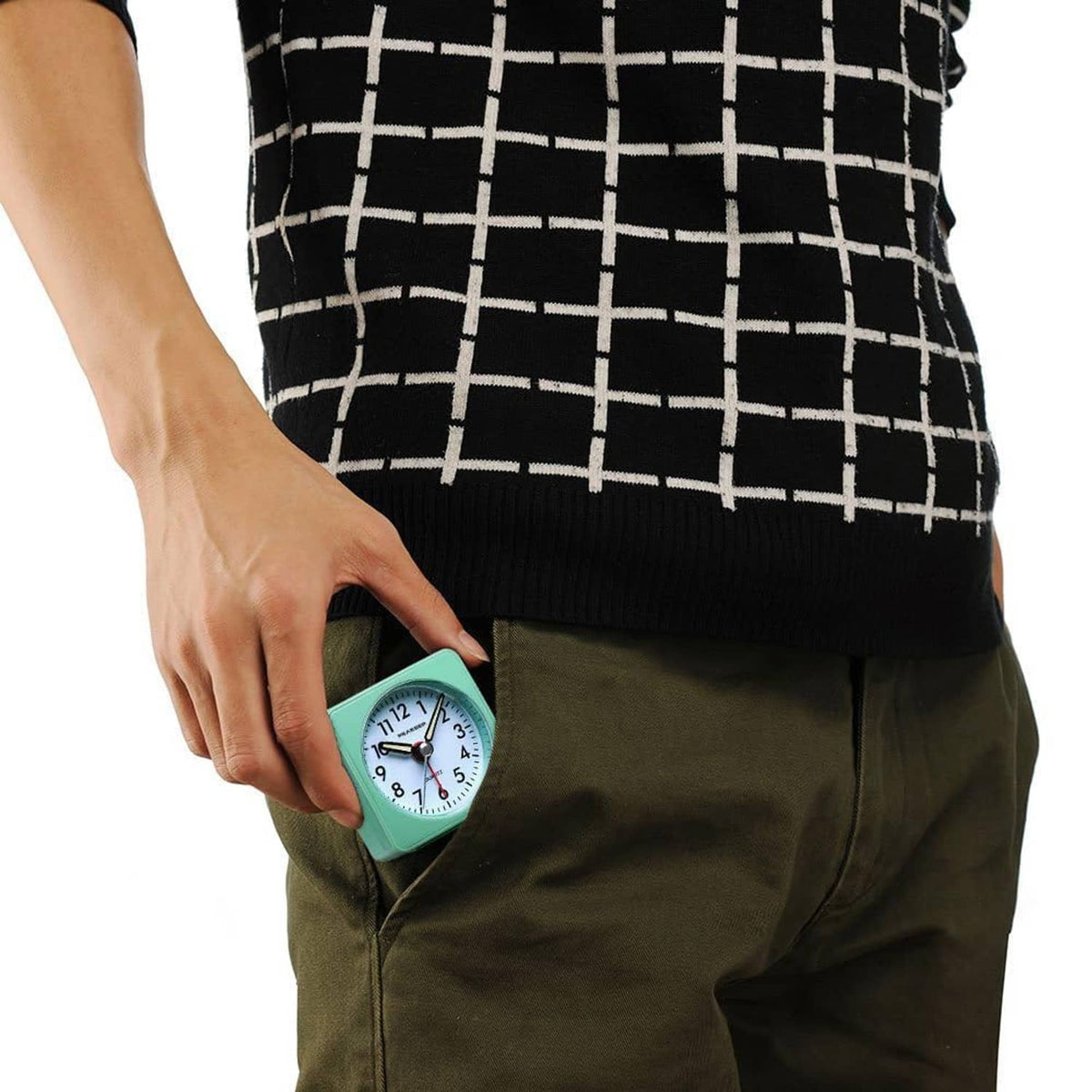 Mini travel alarm clock held near pocket, mint teal case with analog dial