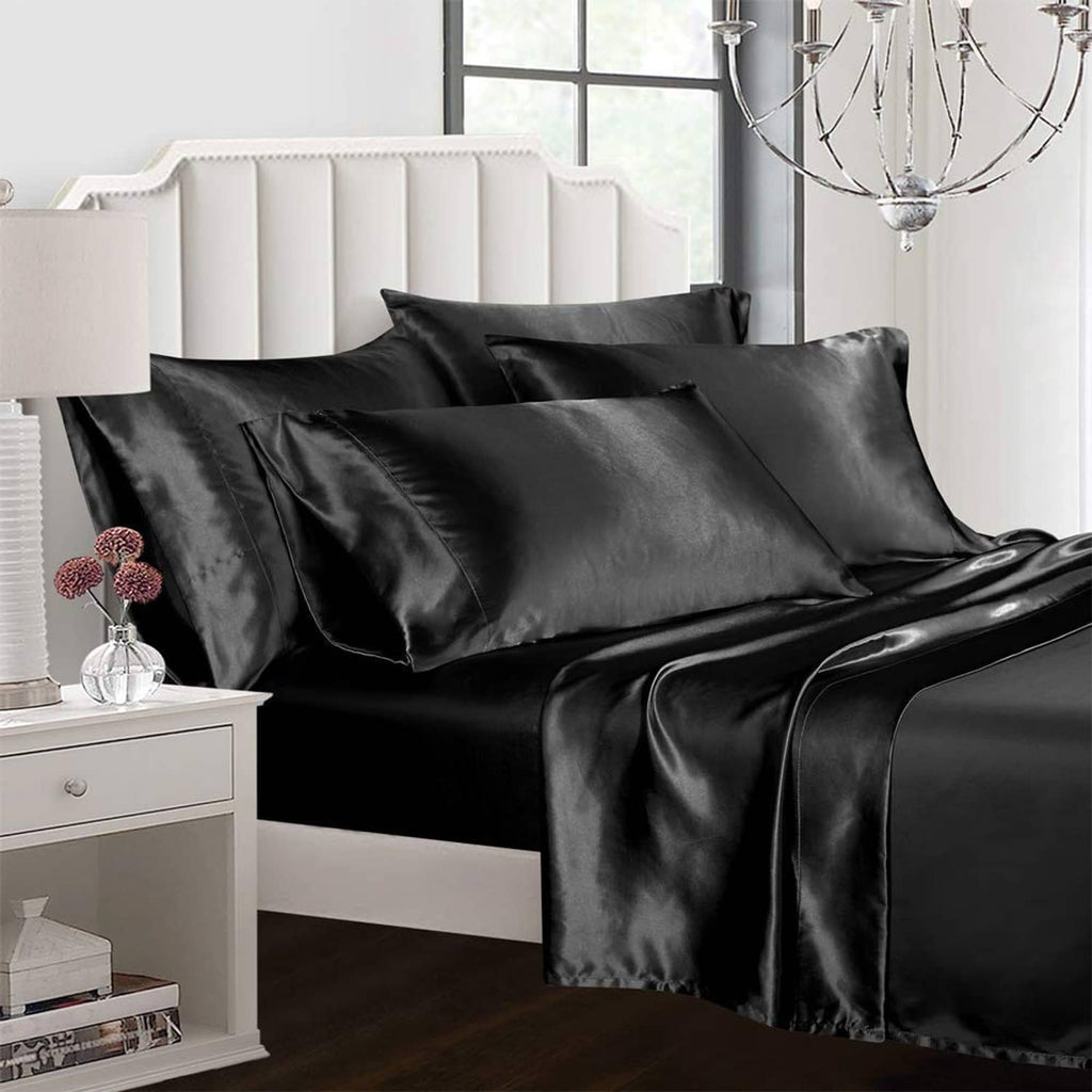 Black satin bedding sheet set on queen bed with pillowcases and draped flat sheet