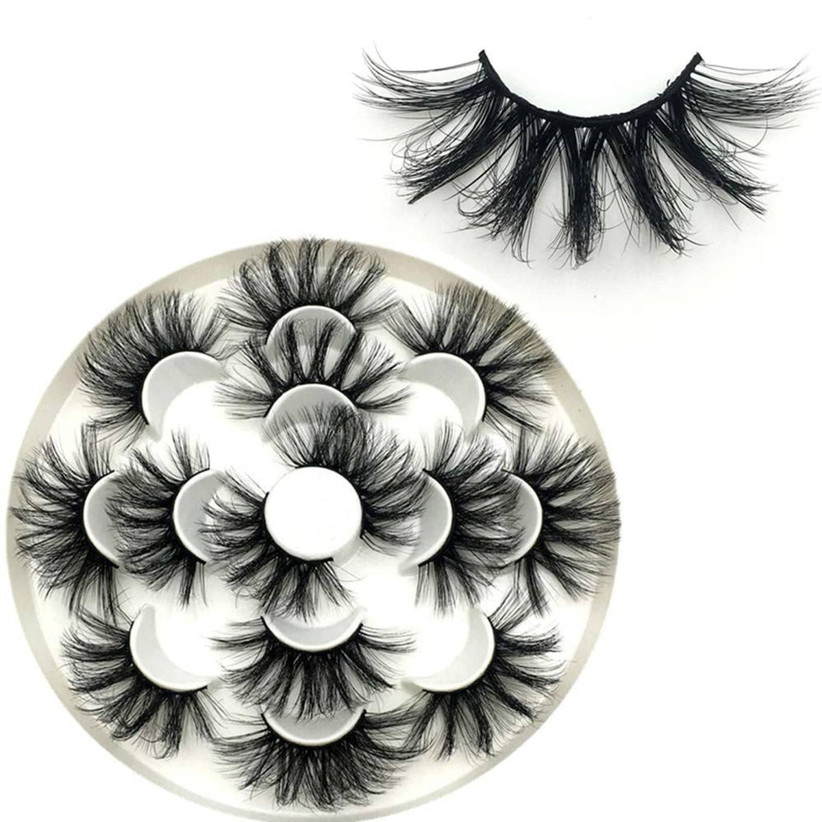 Long wispy black false eyelashes with layered clusters displayed on a round tray.