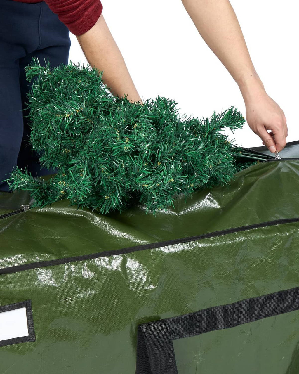 Green tree storage bag cover with zipper opening, shown being pulled closed.