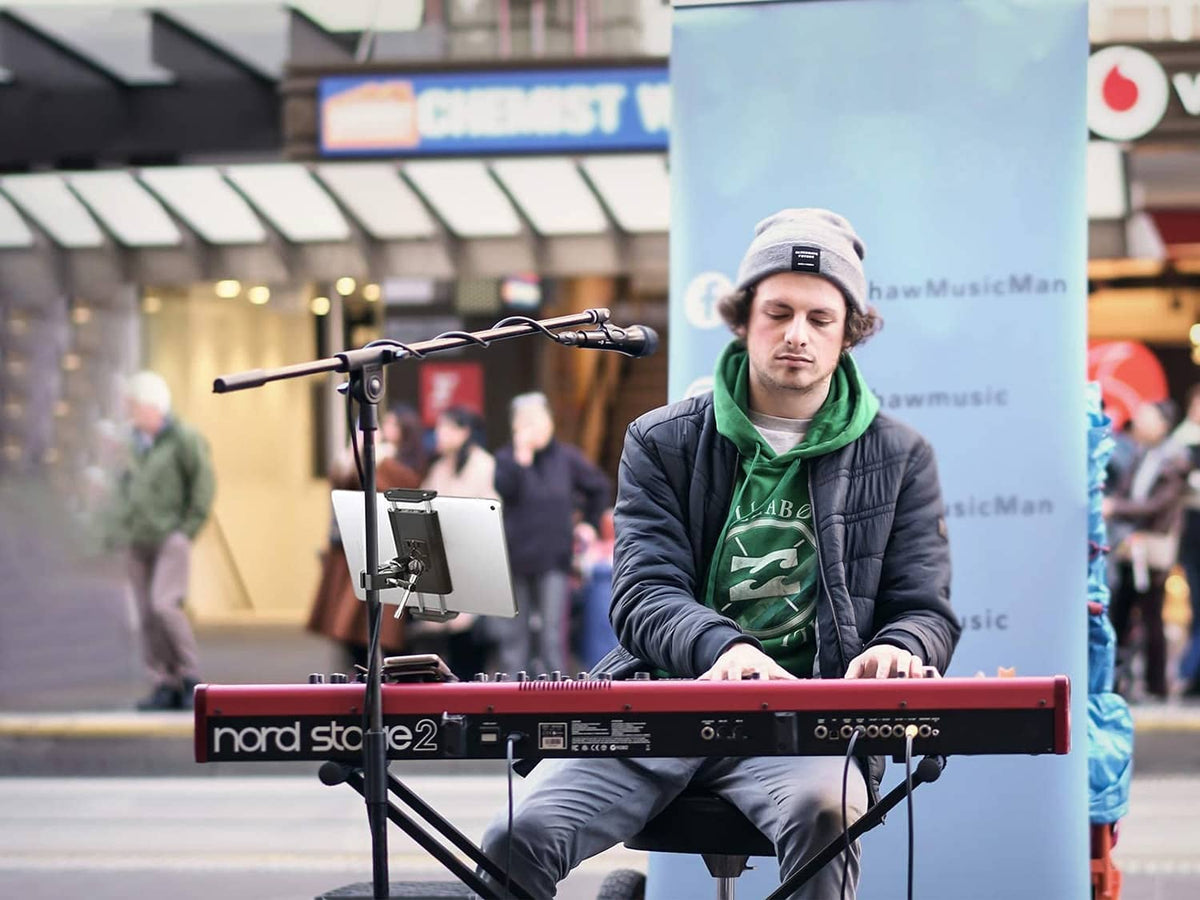 Tablet holder on mic stand with tablet visible during live stage performance