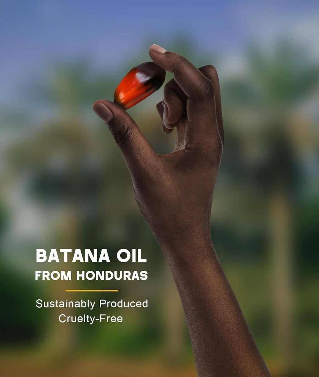 Batana oil dropper releasing amber oil onto wrist, small bottle in hand