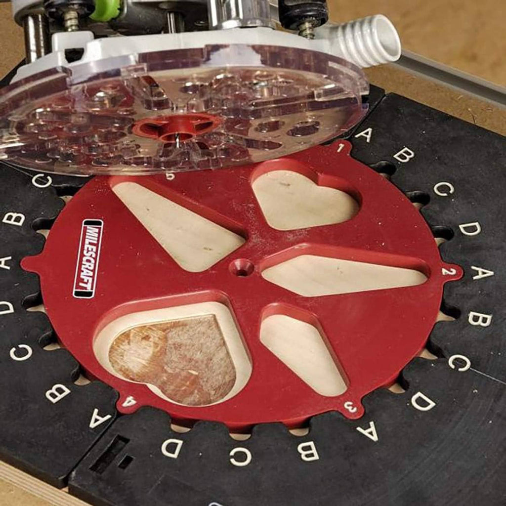 Close-up of red circular router inlay template on black jig base with guide disc