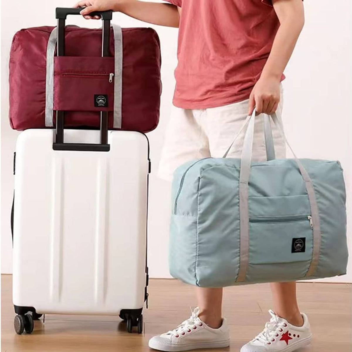 Burgundy and light-blue foldable duffel bags with webbing straps and front pocket