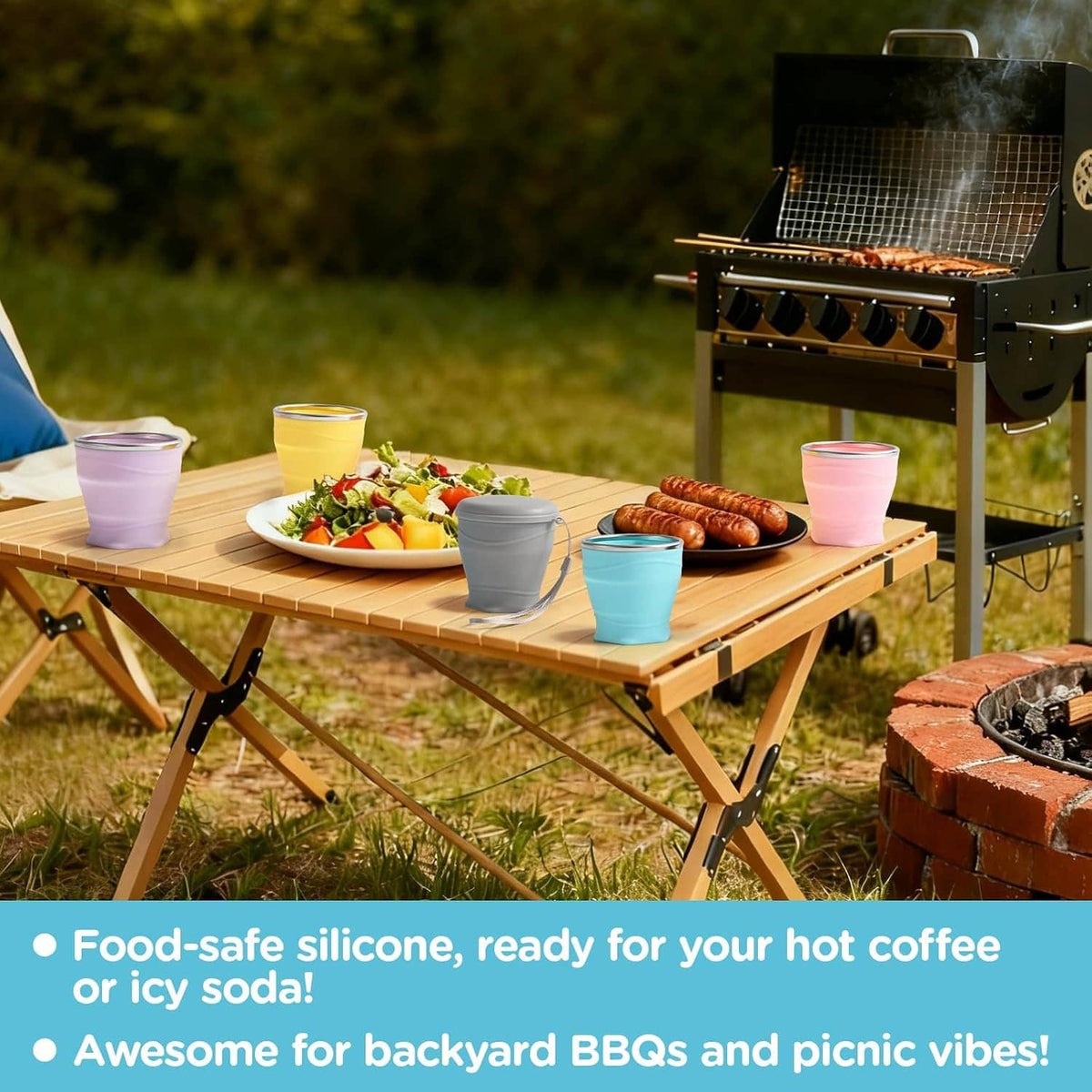 Collapsible silicone cups, pink and blue, with lids on outdoor picnic table