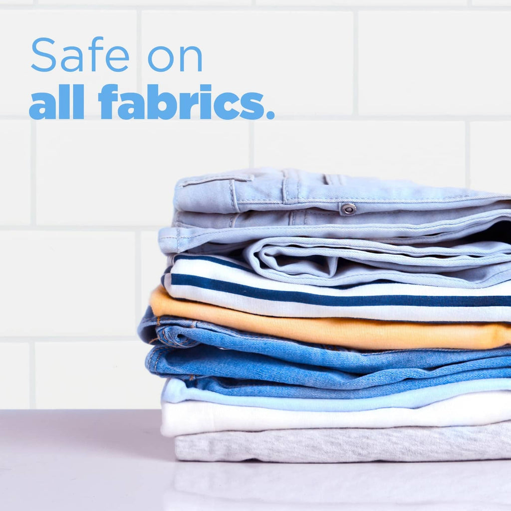 Laundry detergent pods; stack of folded shirts in light blue and white tones