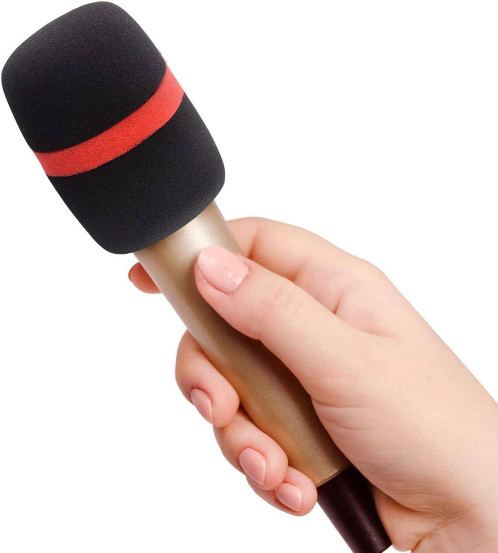 Hand holding handheld microphone with black foam windscreen and red band
