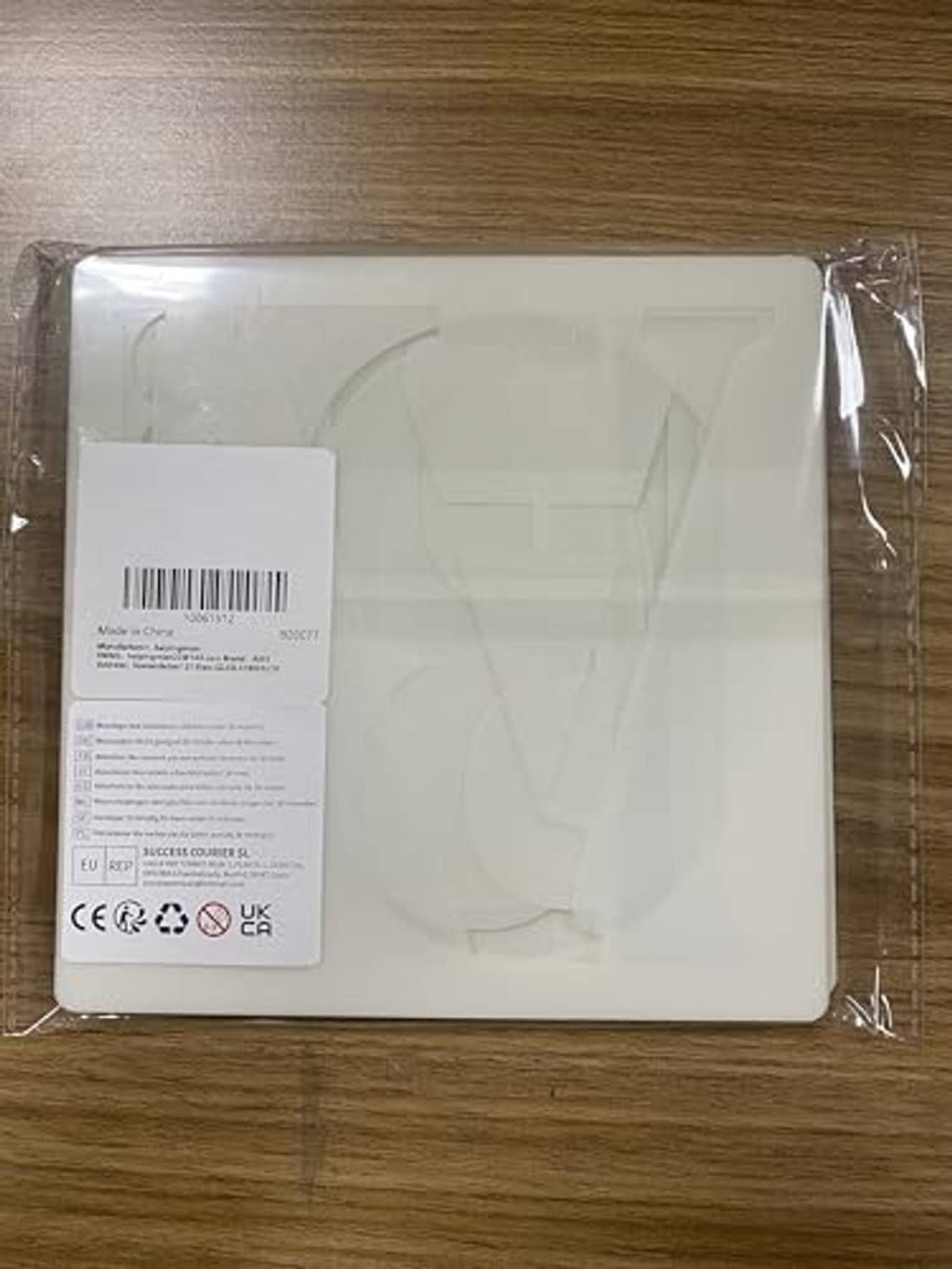 Packaged white plastic stencil sheet with label, sealed in clear protective film