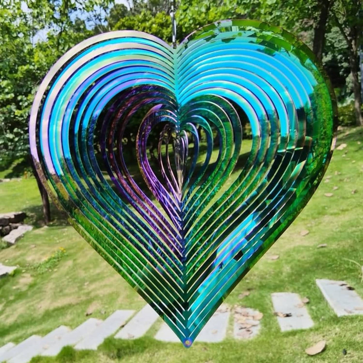 Heart-shaped metal wind spinner with teal, purple, and green iridescent ring stripes