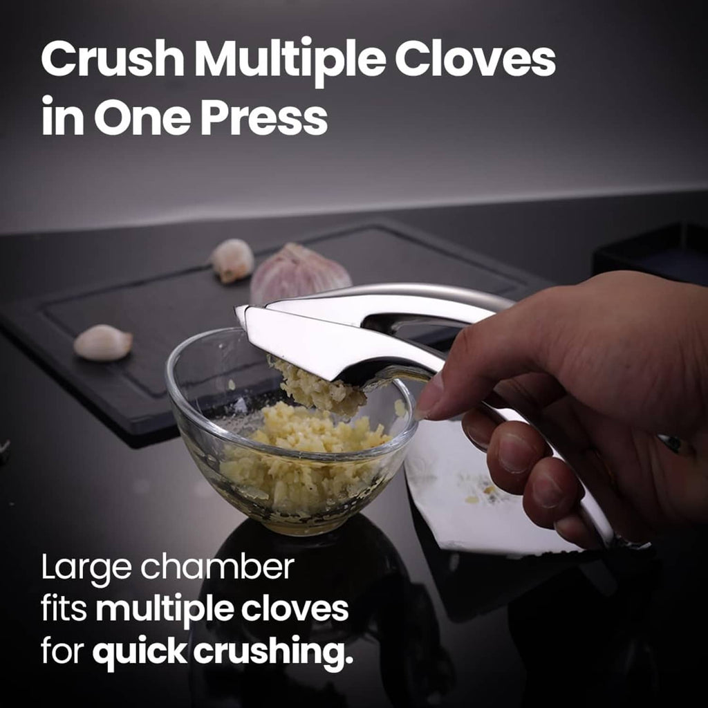 Stainless steel garlic press over a bowl, crushing garlic with one squeeze
