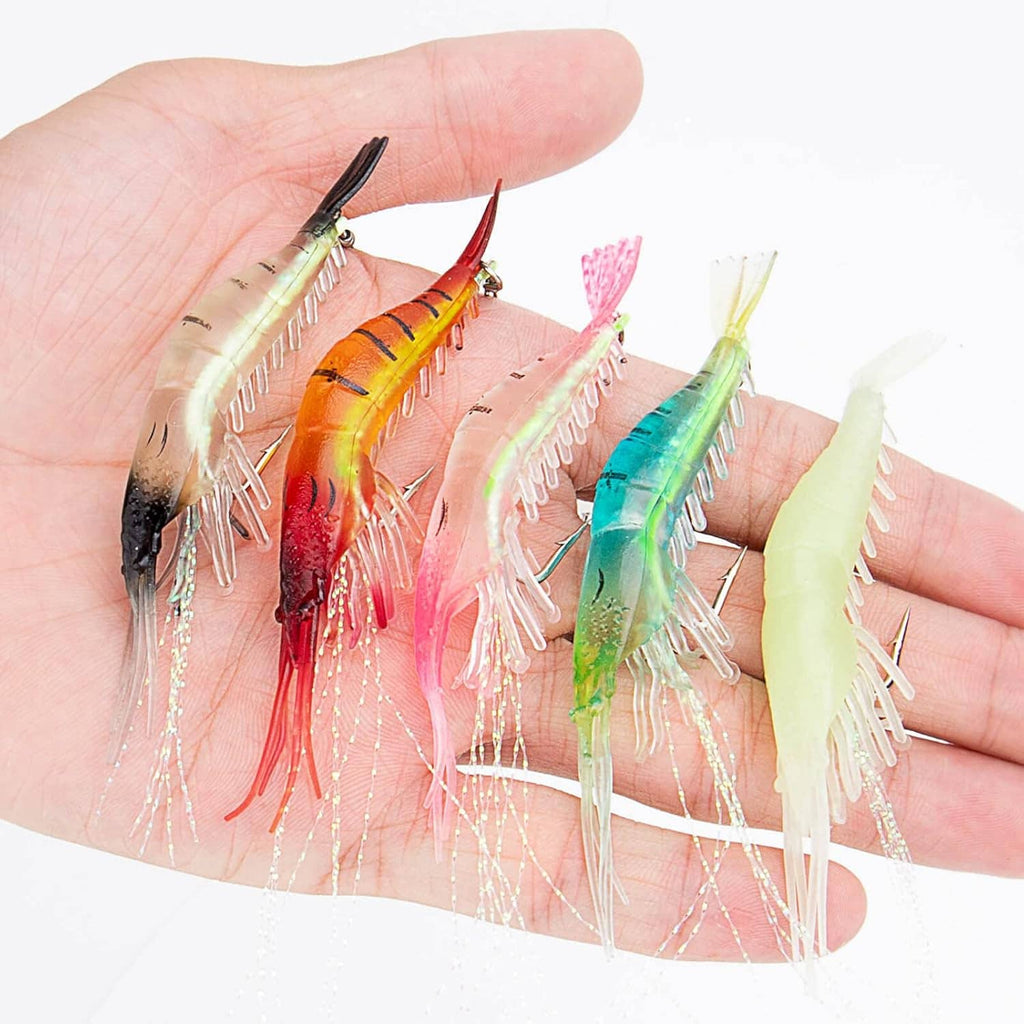 Soft shrimp lures in hand, multicolor bodies with long white skirt strands