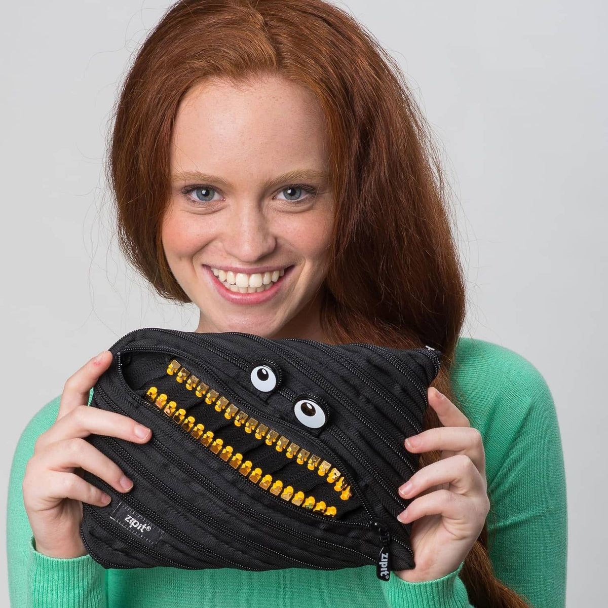 Black ZIPIT pencil case pouch with gold zipper teeth and two eye patches on front