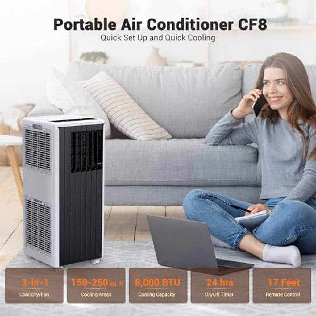 Portable air conditioner with white body and dark vertical front grille, next to sofa.