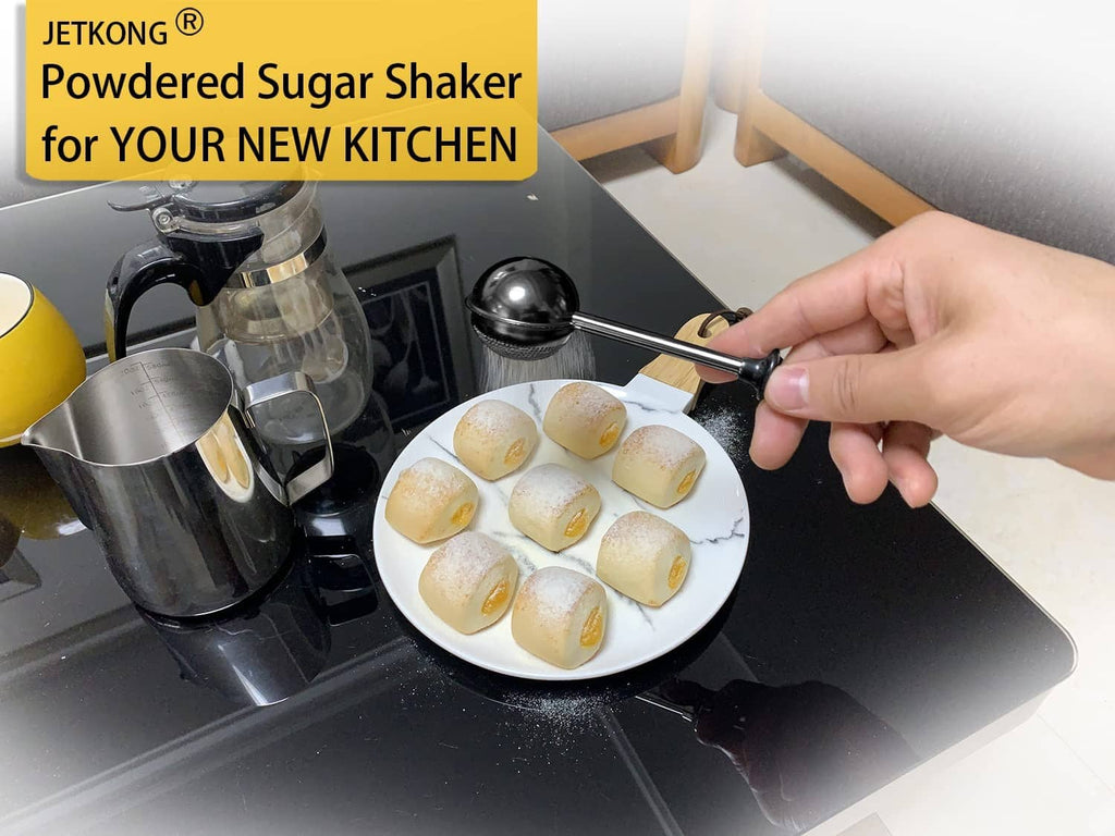 Black powdered sugar shaker duster dispensing over pastries on a plate