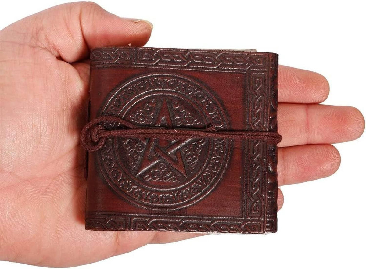 Leather mini pocket notebook held in hand, circular emblem embossing, dark tie cord