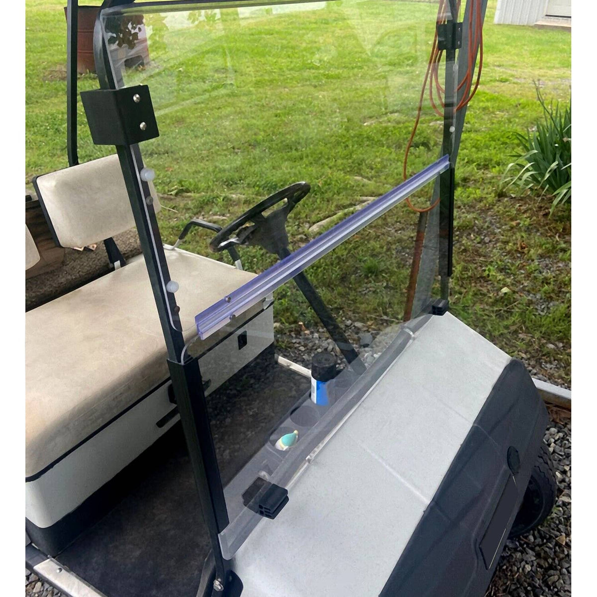 Front corner view of clear windshield with blue frame bar and black mounting hardware