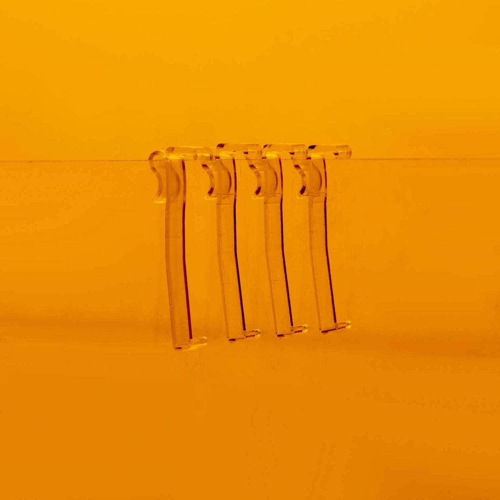 Clear plastic valance clips hanging from the top of a window blind
