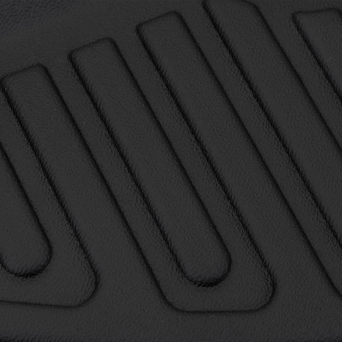 Close-up of black TPE floor mat texture with parallel ridges for grip and drainage