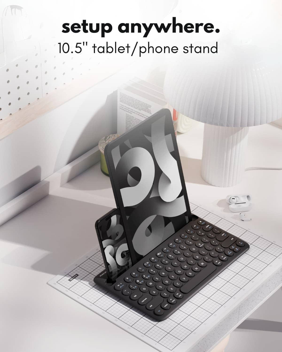 Black compact Bluetooth keyboard propped on a tablet phone stand