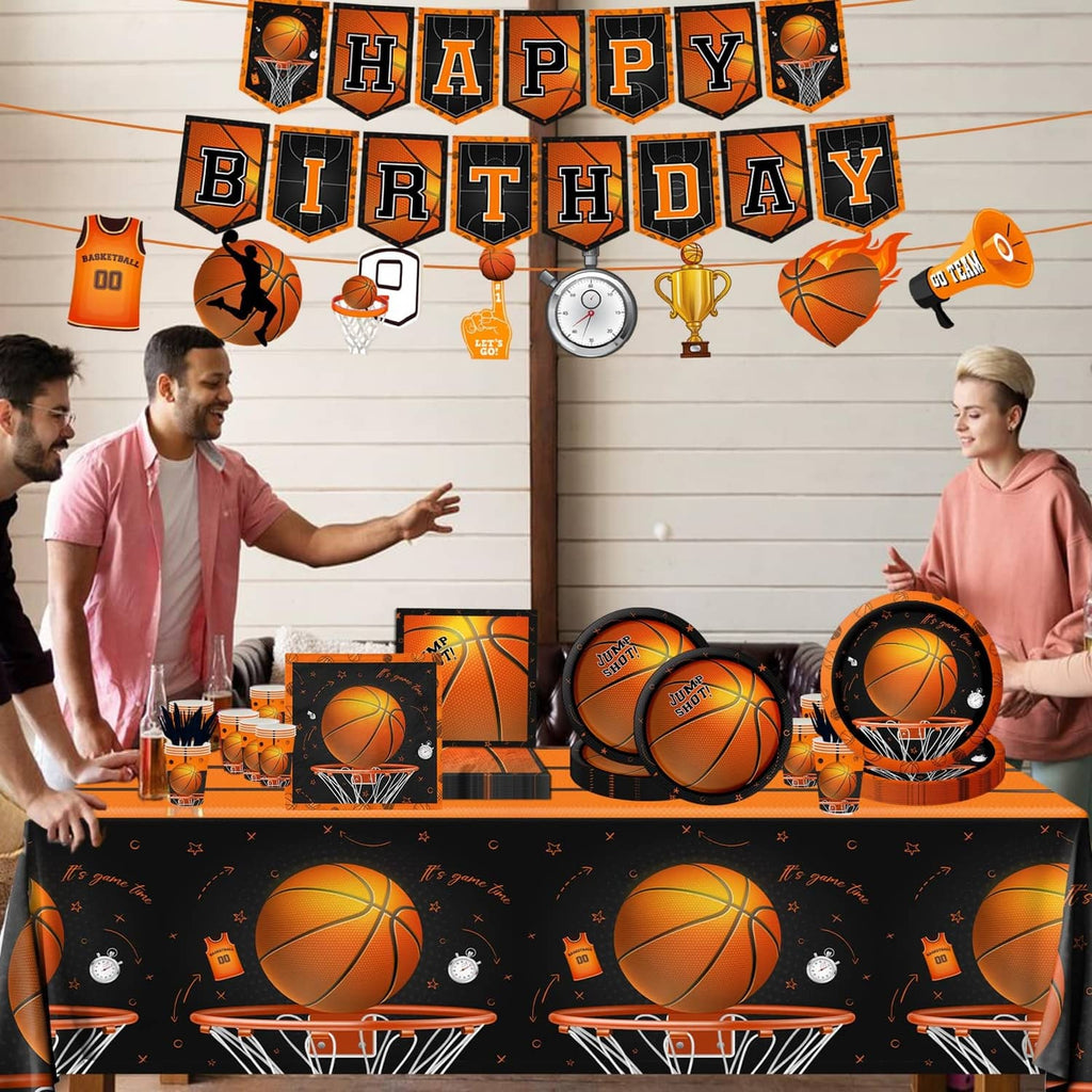 Basketball birthday table setup with black-orange tablecloth, plates, cups, and banner