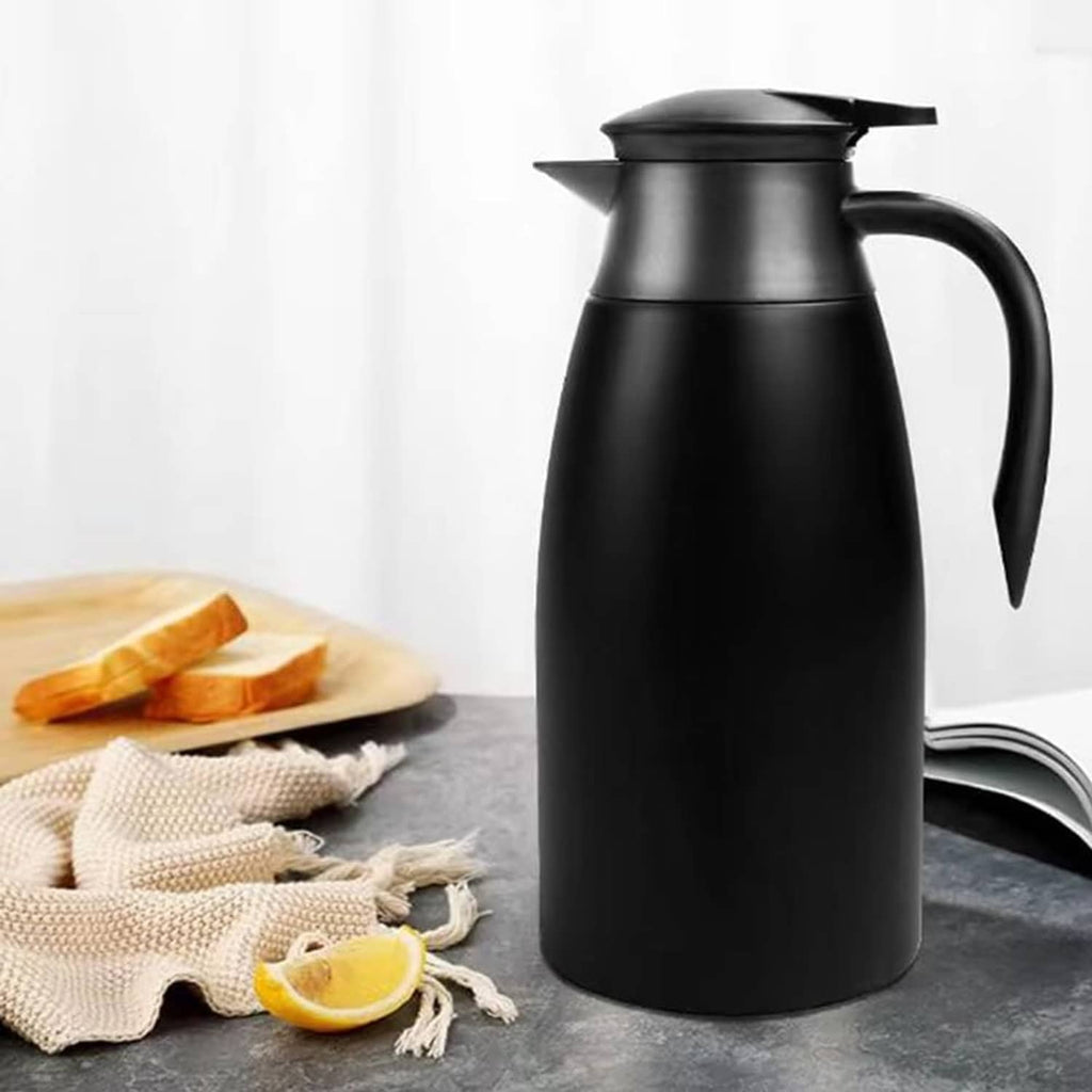 Black insulated coffee carafe on countertop with lemon and folded cloth