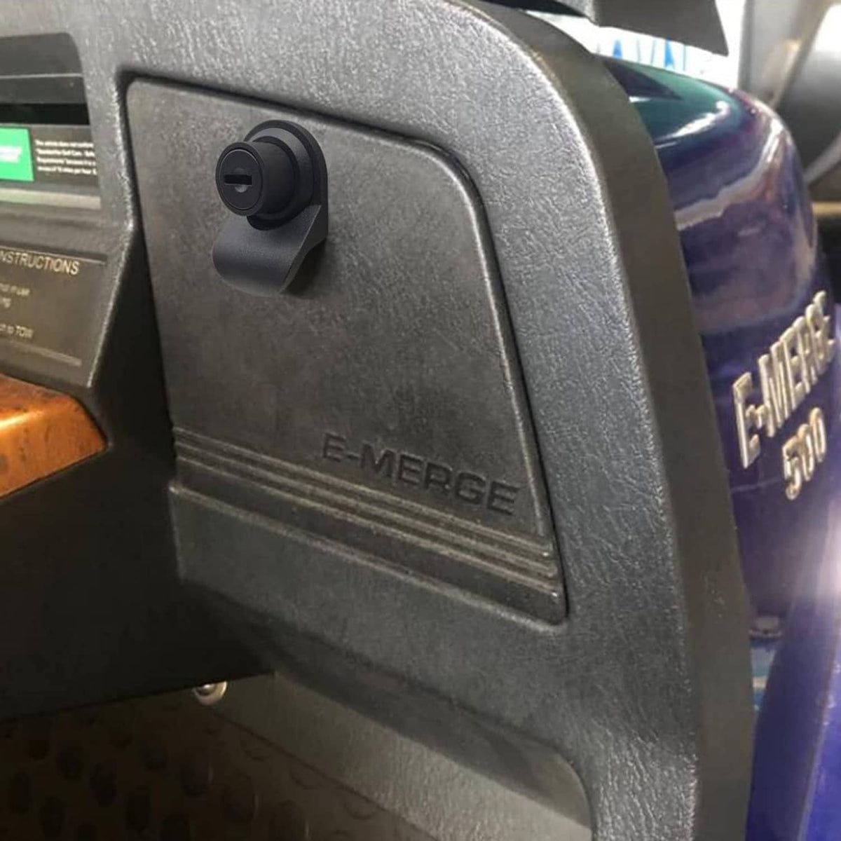 Black glove box latch installed on vehicle dashboard with E-MERGE text