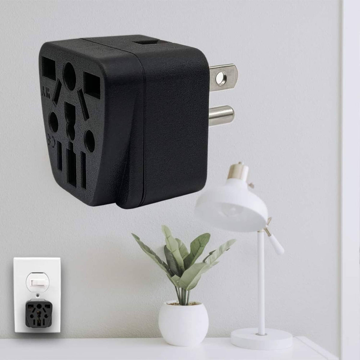 Black travel plug adapter mounted in wall outlet with compact two-prong plug