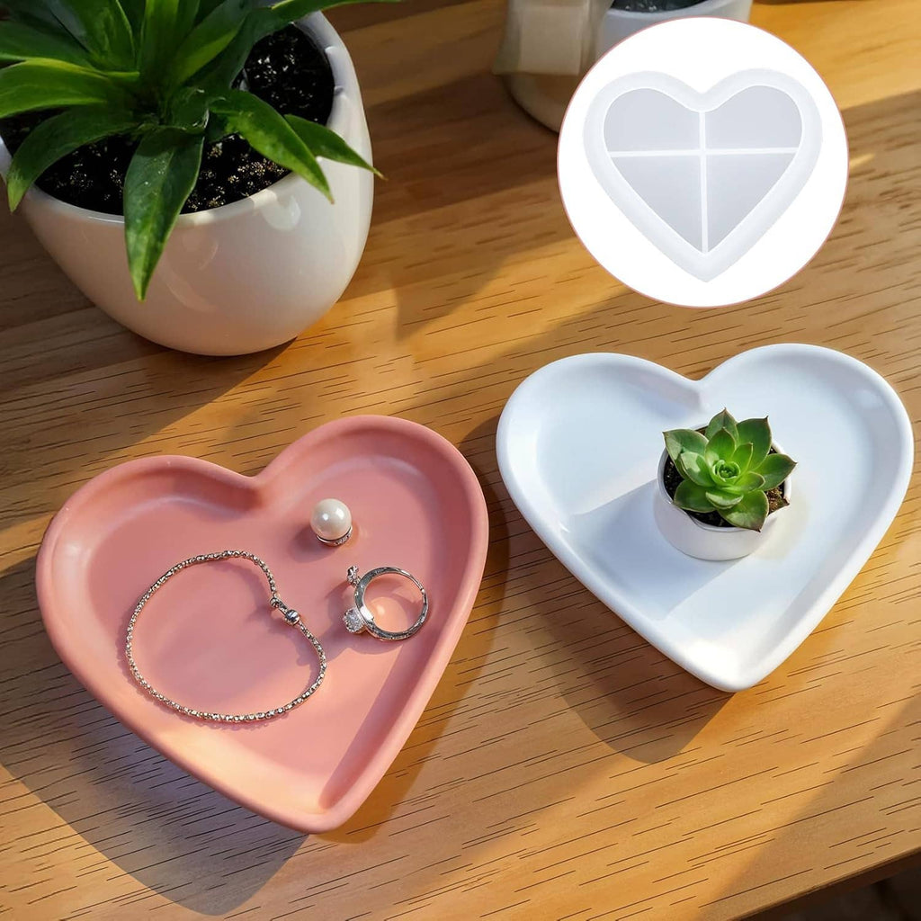 Pink and white heart resin trays holding jewelry and a small potted succulent