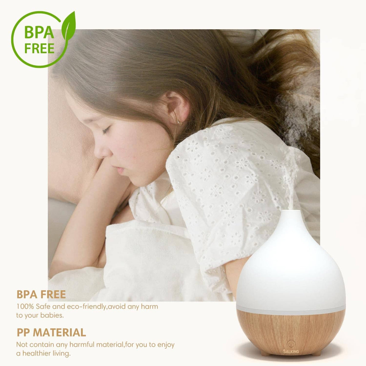 White essential oil diffuser with light wood base next to a sleeping child