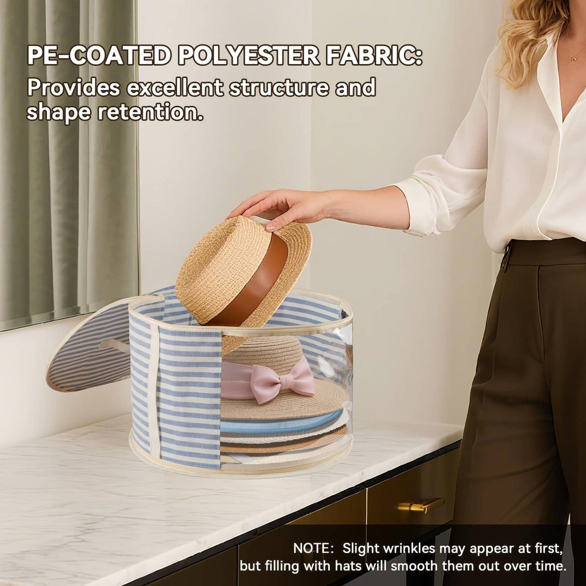 Round hat storage box with clear window, blue striped fabric, open top held by hand.