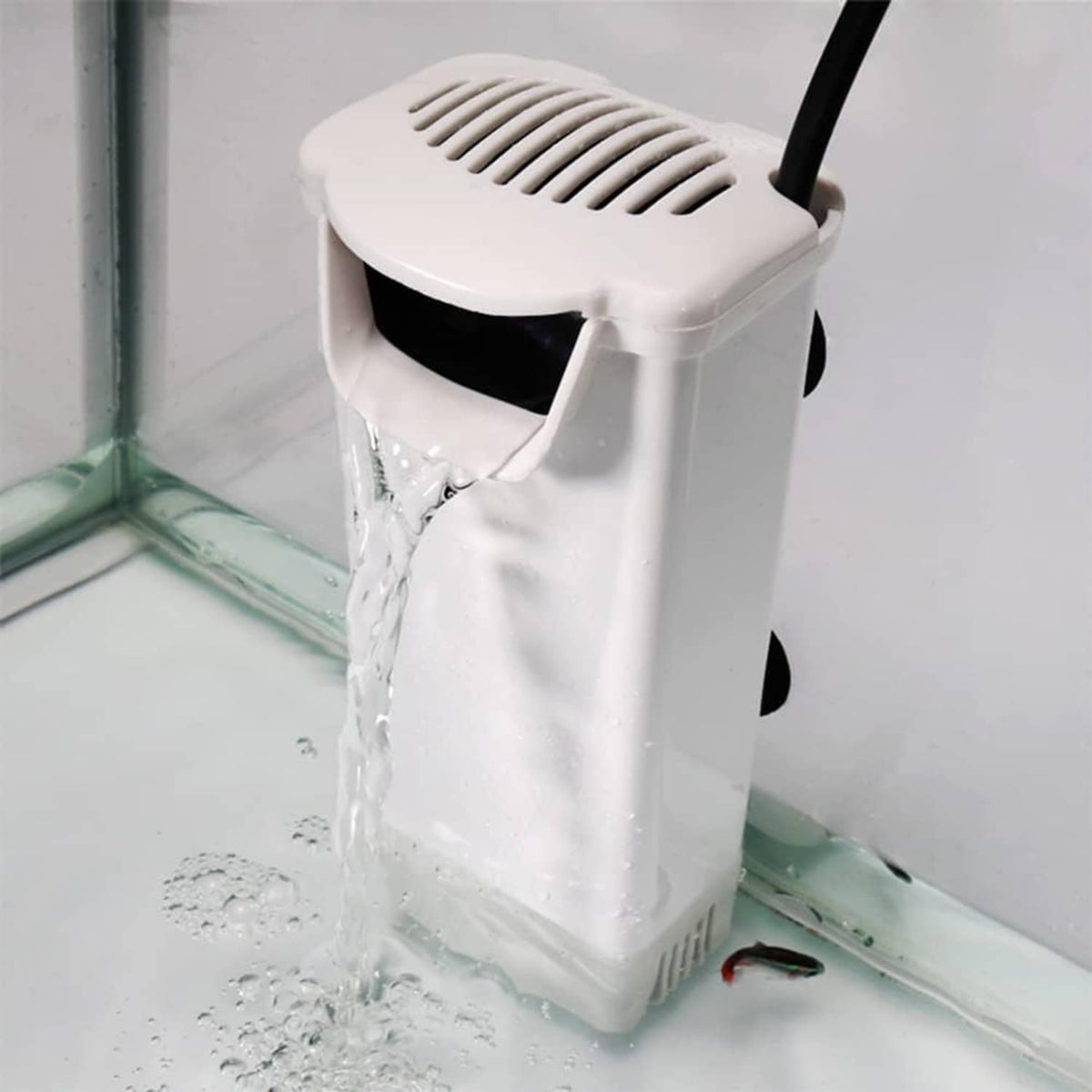 White aquarium filter canister pumping water flow through outlet into tank