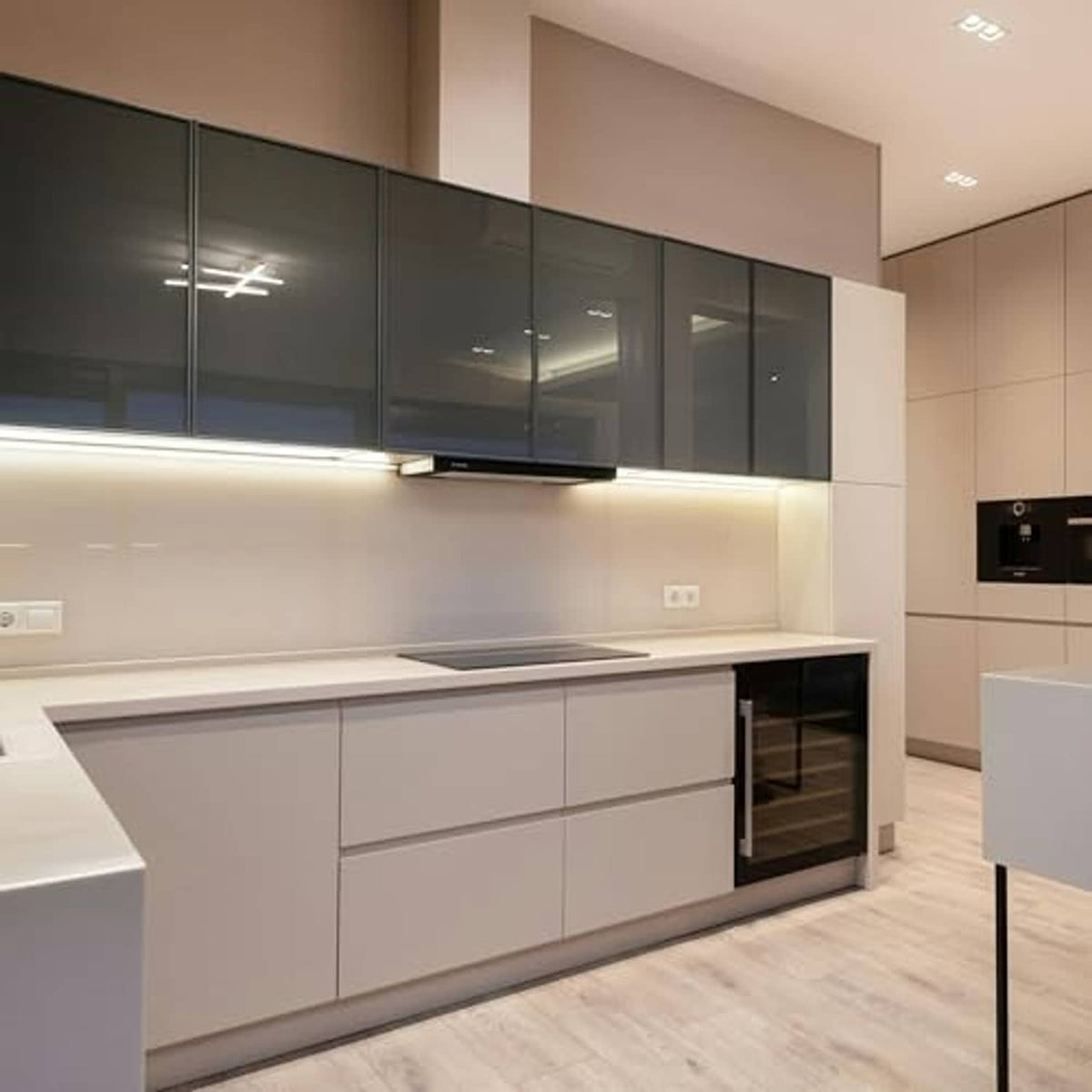 Under-cabinet LED lighting glow in a modern kitchen with light cabinetry