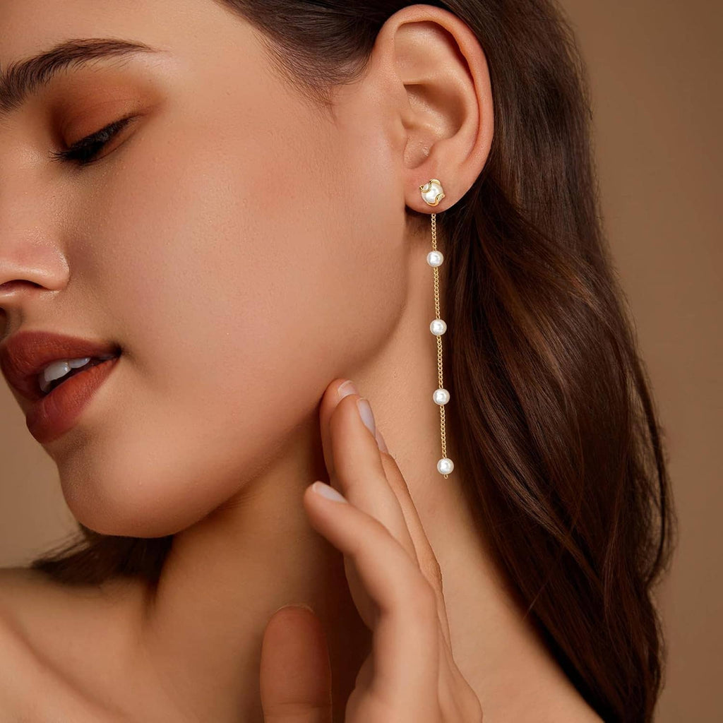 Long gold pearl drop earrings with white pearl dangles on model