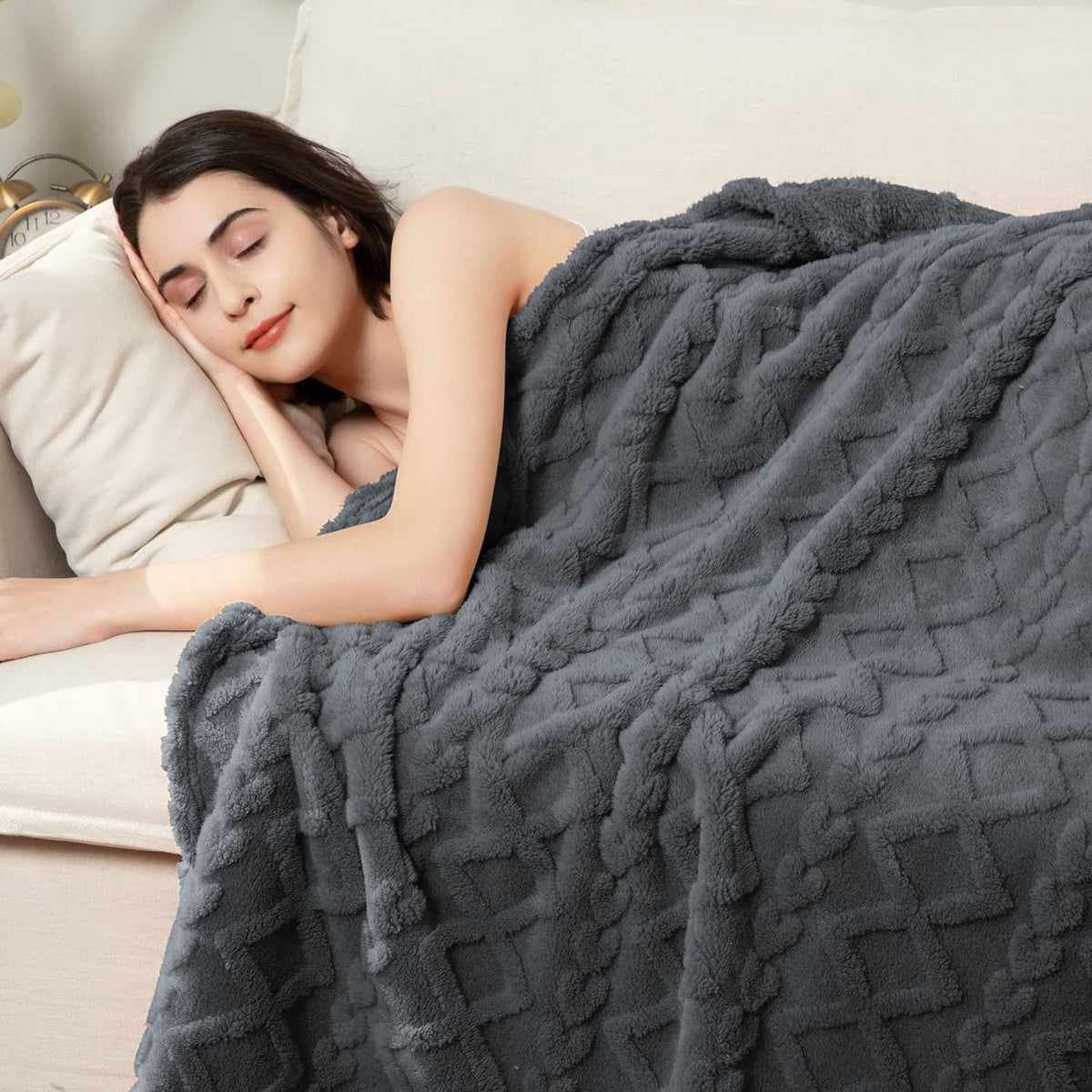 Gray textured fleece blanket draped over sofa with raised grid pattern